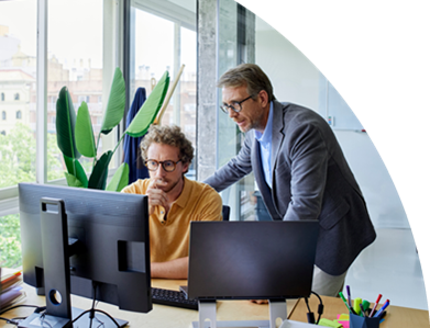 Zwei Männer konzentrieren sich auf ihre Computerarbeit in einem Büro.
