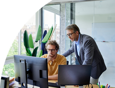 Zwei Männer konzentrieren sich auf ihre Computerarbeit in einem Büro.